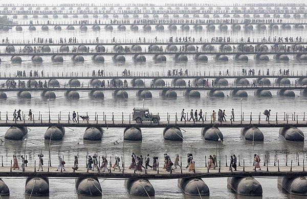 Hindistan'daki Mama Kumbh Mela köprüsü ve ayine giden insanlar. Her 12 yılda bir karşılaşılan bir görüntü