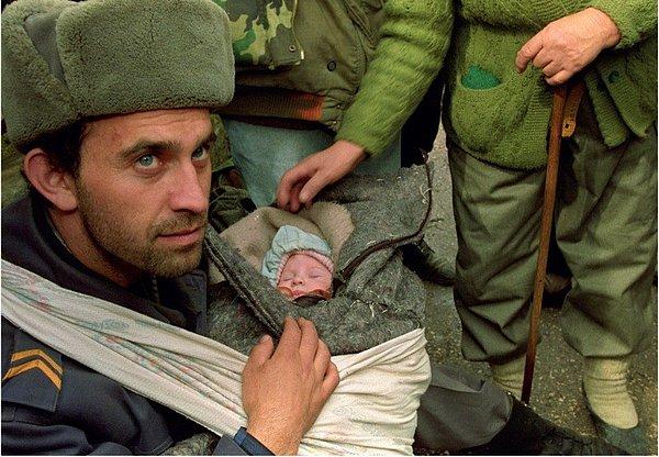 12. Bosnalı bir asker Goradze'nin tahliyesi sırasında bulunmuş olan bir çocuğu kucağında korumaya çalışıyor.