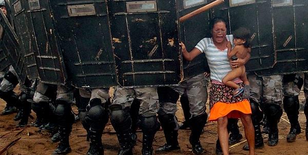 24. Yerli bir kadın, kucağında çocuğunu tutarak kendilerini evlerinden etmek isteyen polislere direniyor. (2008)