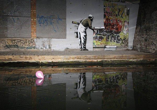 8. Sokak sanatı ve yetkililerin sokak sanatı algısına çok zeki bir şekilde yorum getiren, 2009 yılında yapılmış efsane Banksy eserlerinden bir tanesidir.
