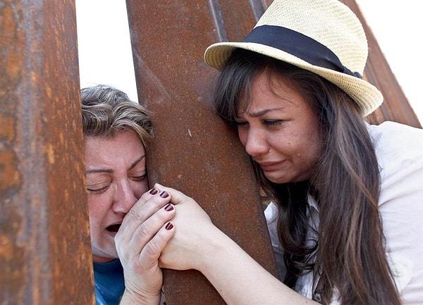 8. Çitlerin ardından el ele tutuşan Gorete Borges Teodoro ve kızı Renata Teodoro. Nogales sınırı, Arizona, 2013.