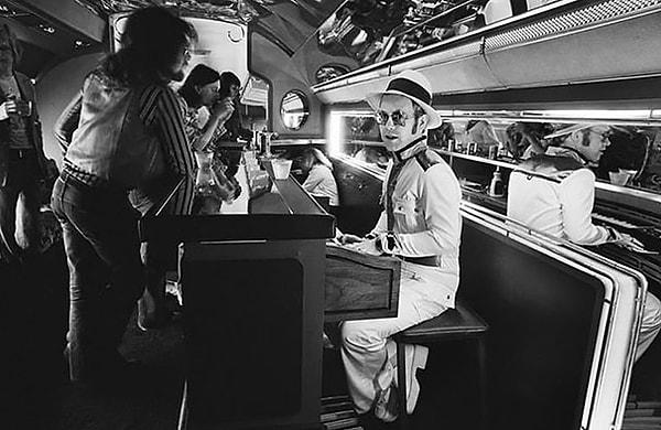 46. Elton John, kendi özel uçağında piyano çalarken, 1976.
