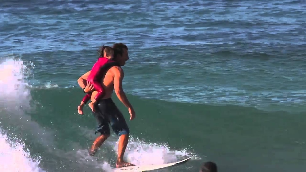 Sırtında Çocuğu ile Sörf Yapan Adam