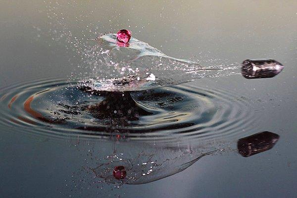 34. Yüksek hızda fotoğraf çeken bir makineden kurşunun su üzerindeki yansıması