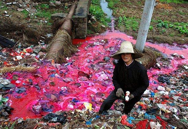 12. Nehirden topladığı plastik şişeleri, kenarda biriktiren kadın.