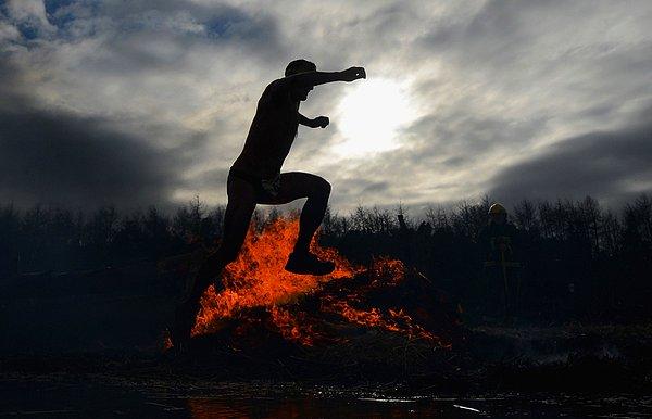 13. Ateşlerle boğuşan, ateşin üzerinden atlayan bir yarışmacı.