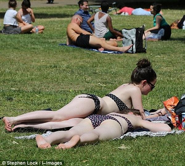 2. Güneş yüzünü gösterir göstermez bikinili kızların ve şortlu erkeklerin parklarda güneşlenmesi.
