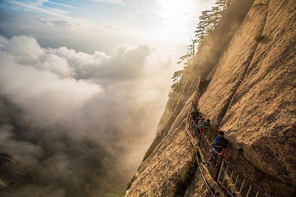 11. Eğer Huashan Dağına çıkmayı düşünecek kadar cesursanız, hemen yanındaki dik uçurum, pek de sağlam durmayan bir merdiven, dağın yüzeyine yerleştirilmiş tahta bir patika sizin için önemli olmayacaktır. Olur da bu tehlikeli tırmanıştan sonra tepeye ulaşırsanız, bulutların üzerinden Çin' in Shaanxi eyaleti keyifle izleyebilirsiniz.