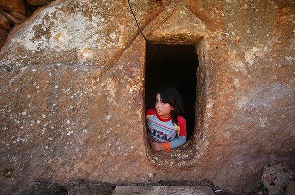 4. 9 yaşındaki Nihal, Suriye'de devam eden savaştan korunan sivillerin bulunduğu bir lahitte, pencereden dışarı bakarken.