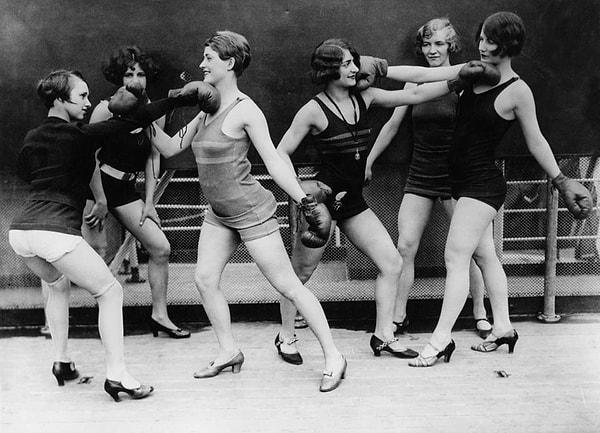 9. 1920'lerde topuklu ayakkabılarıyla bir grup kadın boks eldivenleri giyerek bir maçı canlandırmaları.