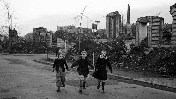 32. Okuldan eve paten süren üç kız, müttefik kuvvetlerin hava saldırısına maruz kalarak yıkılmış binaların arasından geçerken, 14 Şubat 1949