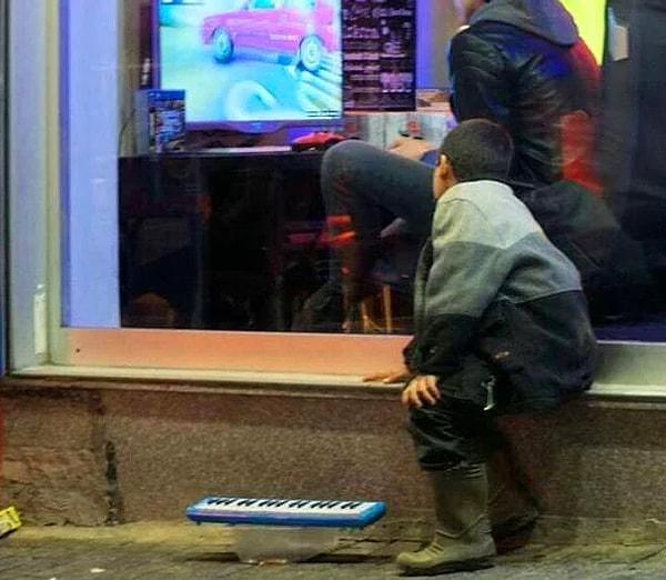 7. İstanbul'da objektiflere takılan bir fotoğraf... Oyun salonunda PlayStation oynayanları camın ardından izleyen bir çocuk. Belli ki yere bıraktığı oyuncak orguyla para kazanmaya çalışıyor ama o an aklı içeride. Ve sonra...