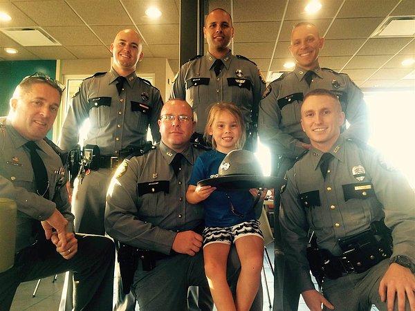 11. 5 yaşındaki bir kız sadece onları gülümsetmek adına eyalet polisleri için dondurma satın aldı ve hep beraber bu hatıra fotoğrafı çektirdiler.