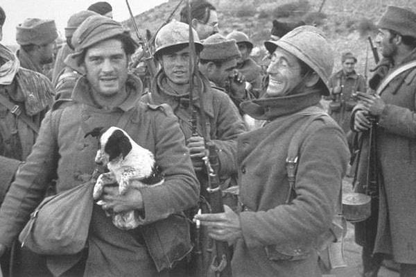 11. George Orwell İspanya iç savaşı sırasında kucağında köpekle, arka tarafta Ernest Hemingway de görülebilir, 1937.