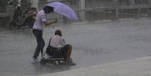 4. Bu insanlık dersi veren kadın ise yoğun bir yağmurda engelli ve evsiz adama yardım etme uğraşında.