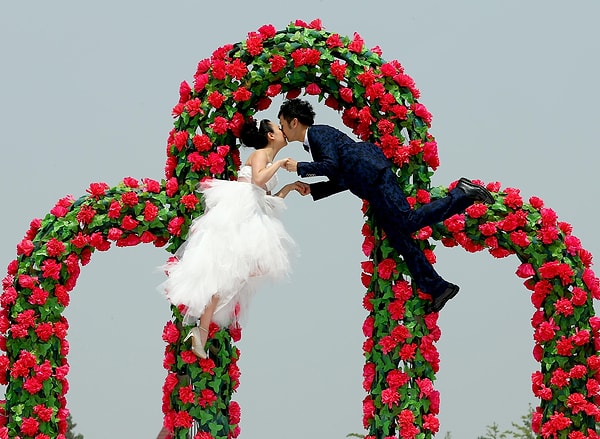 Китайский фокусник Фу Яндонг парит в воздухе во время свадебной церемонии со своей невестой Чен Хун в Пекине в июне 2015.