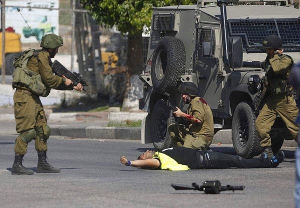 15. İsrailli bir asker, El Halil'deki çarpışmalar sırasında başka bir İsrailli askeri bıçaklayan Filistinli adamı vuruyor. 16 Ekim 2015.