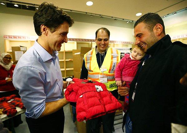 23. Kanada başbakanı Justin Trudeau, Ontario'daki Toronto Pearson Uluslararası Havalimanı'na inen olan Suriyeli mültecilerin çocuklarına mont hediye ediyor. 11 Aralık 2015.