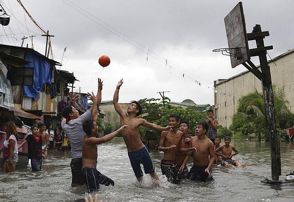 28. Malabon'daki bir sahil köyünde yaşayan Filipinli çocuklar, bir derenin taşması sonucu bölgeyi kaplayan sel suyunun içinde basketbol oynarken. 8 Temmuz 2015.