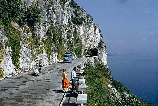 7. Bir körfeze bakan uçurum kenarındaki yolda manzaranın tadını çıkaran insanlar. Trieste, İtalya. 1956.