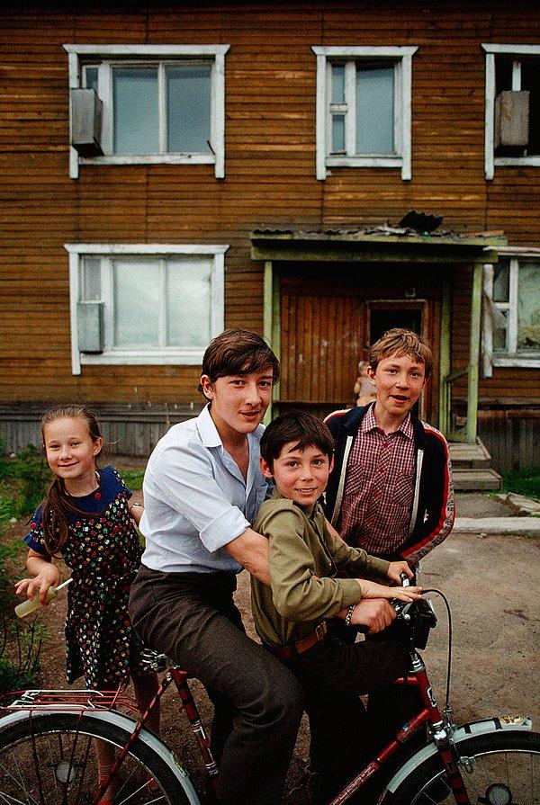34. Kömür madencilerinin çocukları ahşap bir evin önünde oynarken. Sibirya. Eylül, 1988.