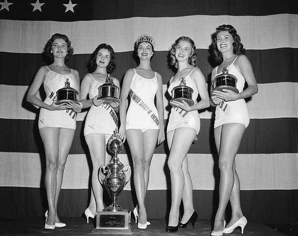 3. В те ранние годы Мисс США был лишь предваряющей частью состязания Мисс Вселенная. На фото можно видеть Мисс США 1957, Леону Гейдж, уступившую звание Мисс Вселенная Гладис Сендер из Перу.