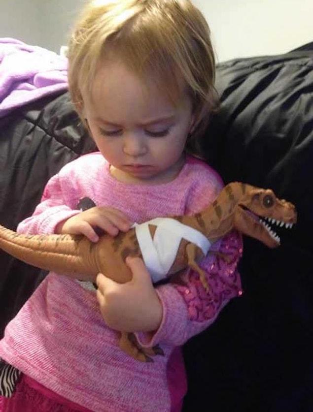 11. Trying to comfort her dinosaur after it's all patched up.