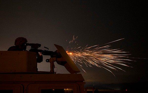 Kaliforniya Fort Hunter-Liggett'de bir ABD askeri M249 otomatik silahıyla gece saldırısı geçerlilik sınavı veriyor.