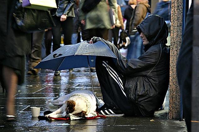 6. This homeless man shows that he actually has a lot by holding his umbrella for his dog.