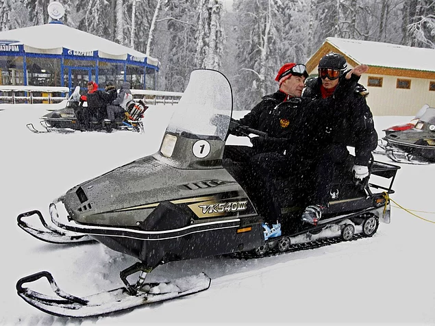 Here, Putin and Russian Prime Minister Dmitry Medvedev ride a snowmobile at an Olympic alpine ski park.