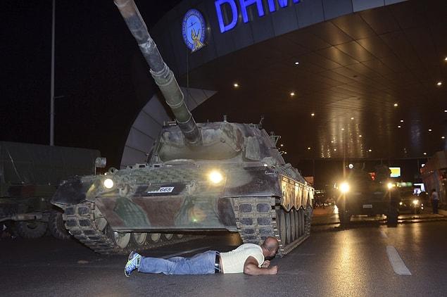 A man lying in front of a tank...