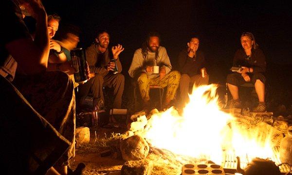 14. Bir kamp ateşinin etrafında oturup sıcak bir kahveyi yudumlamak.