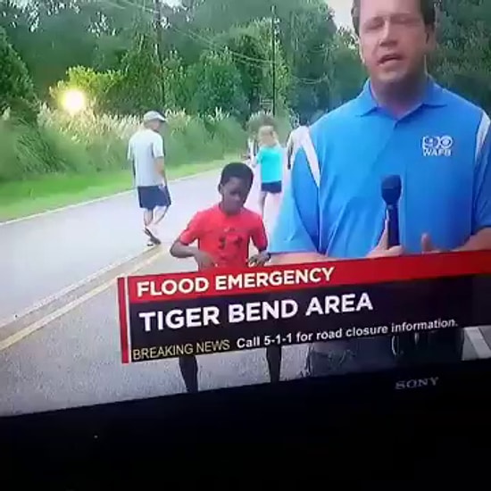 Парень зажигает перед камерой, пока корреспондент делает репортаж с места событий