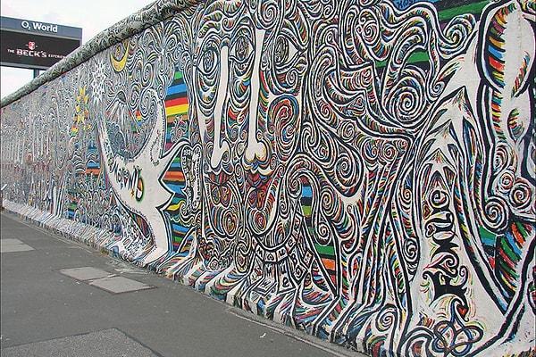 16. Günümüzde Berlin Duvarı'nın bir parçası hala olduğu yerde durmaktadır. Büyük bir turist odağı olan bu parça, sanatçıların yaptığı muhteşem ve anlamlı işlerle renklendirilmiştir.