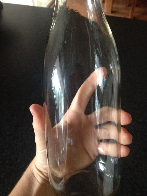 The best way to clean up a bottle with a narrow top is to use eggshells and water! Just shake it thoroughly and you'll see the difference!