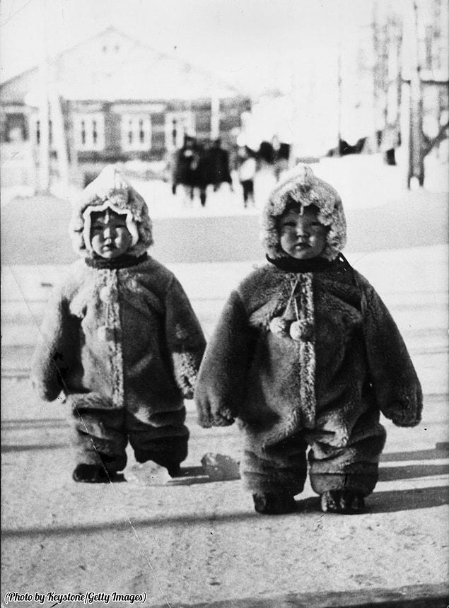 18. Twin toddlers on a Russian street are so well protected against the cold that they look like penguins, 1968.