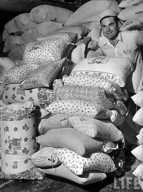 A worker for the Sunbonnet Sue Flour company prepares one of the pattern bags to be loaded with flour. 1939.