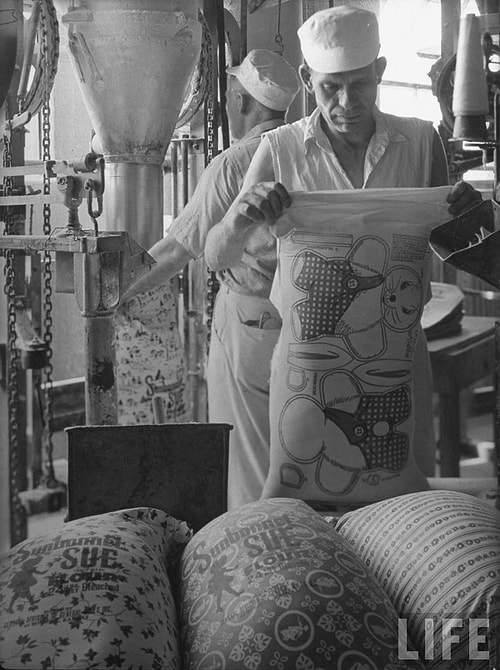 A worker for the Sunbonnet Sue Flour company prepares one of the pattern bags to be loaded with flour. 1939.