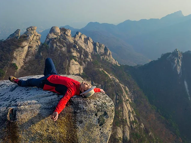 Мужчина отдыхает после скалолазания. Национальный парк Пукхансан, Сеул