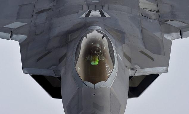 4. A pilot looks up from a U.S. F-22 Raptor fighter as it prepares to refuel in mid-air with a KC-135 refuelling plane over European airspace.