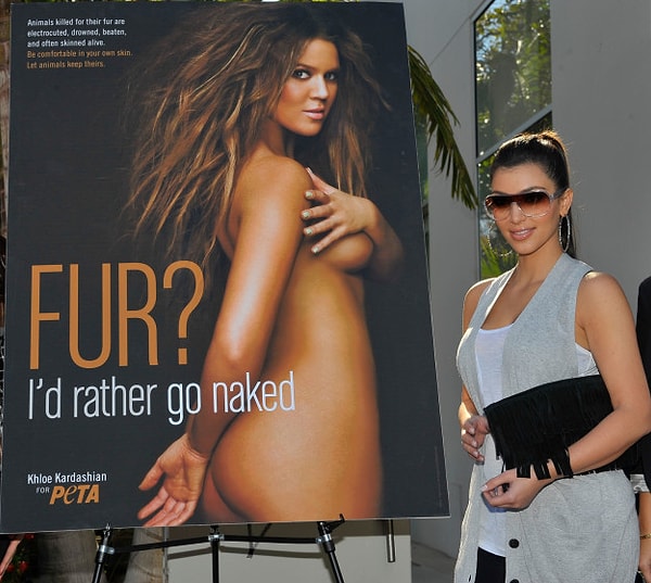 20. Kim Kardashian kız kardeşinin yer aldığı Peta afişinin yanında poz verirken.