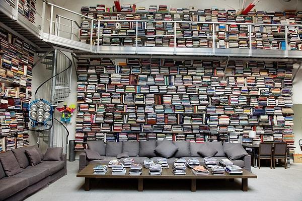 Ev gördüğünüz üzere yüksek tavanlı. Tasarımcı, yukarıdaki kitaplara ulaşmak için merdiven kullanıyor ve kitapların önünde rahatça hareket edebilmek adına da bir platform bulunuyor.