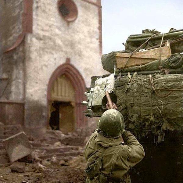 13. "4. Zırhlı Tümen'e bağlı bir Amerikan askeri, kilisenin çan kulesine mevzilenmiş olan Alman sniperla çapışma halinde - Alsas, 6 Şubat 1945."