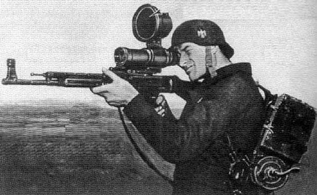 22. German soldier posing with the first modern infantry rifle in history, the StG-44 and Zielgerät 1229. 1945.