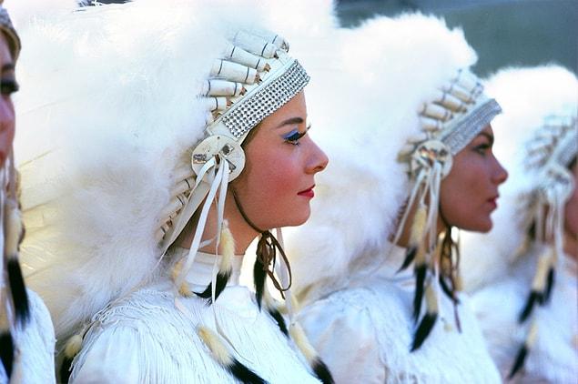 4. Young women dressed in faux headdresses wait on the sideline for the festivities to begin.