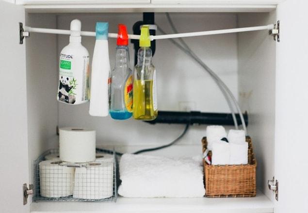 19. Hang bottles on a shower rod to clean up the area under your sink.