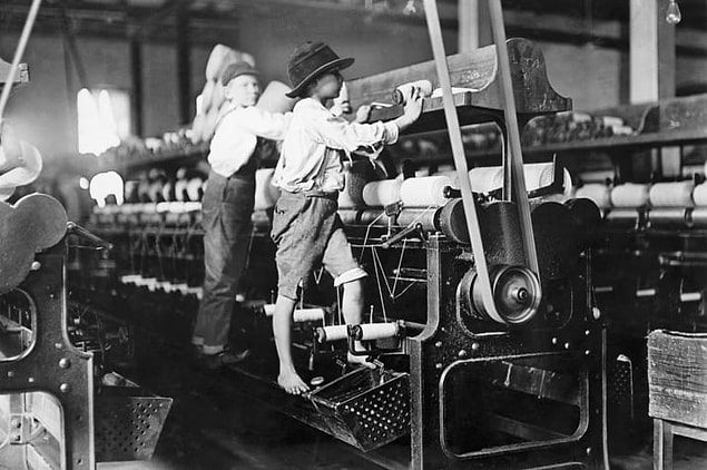 10. A pair of boys are seen working the spindle at a Georgia cotton mill, circa 1900.