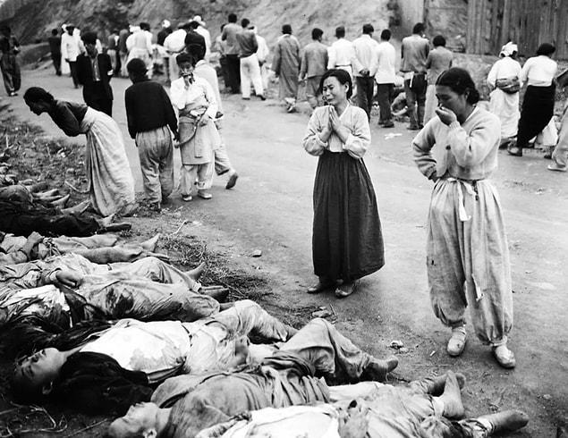14. Korean women weep as they identify family members killed by North Korean forces in 1953. The victims were forced into caves near Hamhung, which were then sealed off so that the men would suffocate.
