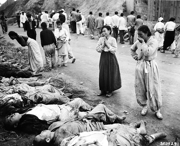 13. Женщины плачут, узнав в этих умерших солдатах членов своей семьи. Жертв загоняли в пещеры с закрытым доступом, чтобы они задохнулись (1953 год)