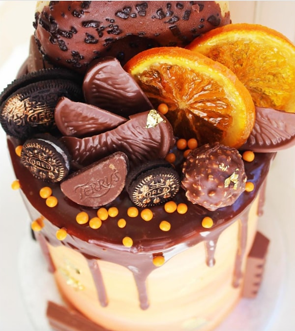 2. Этот торт украшен донатами, дольками апельсина в шоколаде, сушеным апельсином и печеньем Oreo. Кроме того, крем в нем тоже с ароматом шоколада с апельсином!